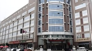 Un hôtel à plusieurs étages, doté d’une façade incurvée, de grandes fenêtres et d’une entrée imposante.