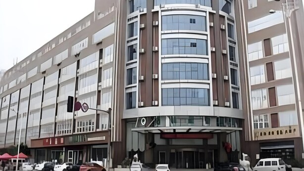 Een hotel met meerdere verdiepingen, een gebogen gevel, grote ramen en een opvallende ingang.