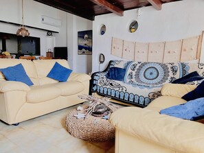 A living room with two sofas, one beige and one patterned, and a woven pouf. - Just a stone's throw from Circeo National Park (San Felice Circeo)