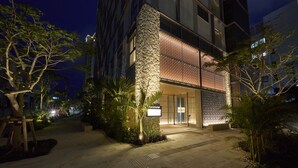 Um edifício moderno com fachada de pedra e entrada em vidro texturizado.