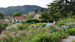 A garden with various flowers and a pathway leading to a building with a red roof. - #2 Cinque Terre, Tuscany, Liguria, Lerici (Lerici)
