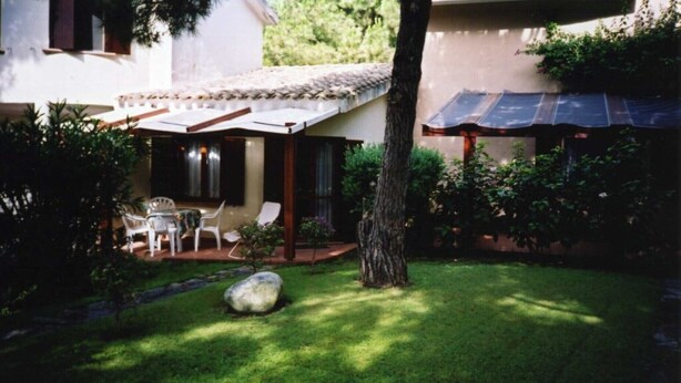 Un espace patio aménagé avec une table et des chaises, une pergola et un chauffe-eau solaire.
