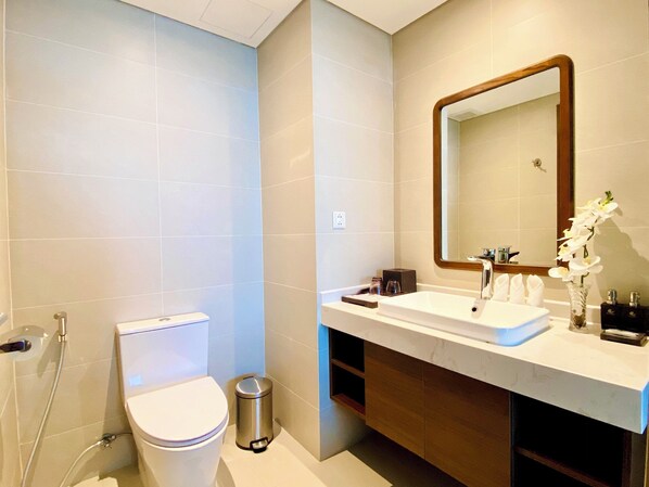 Un baño moderno con inodoro, lavamanos y espejo.