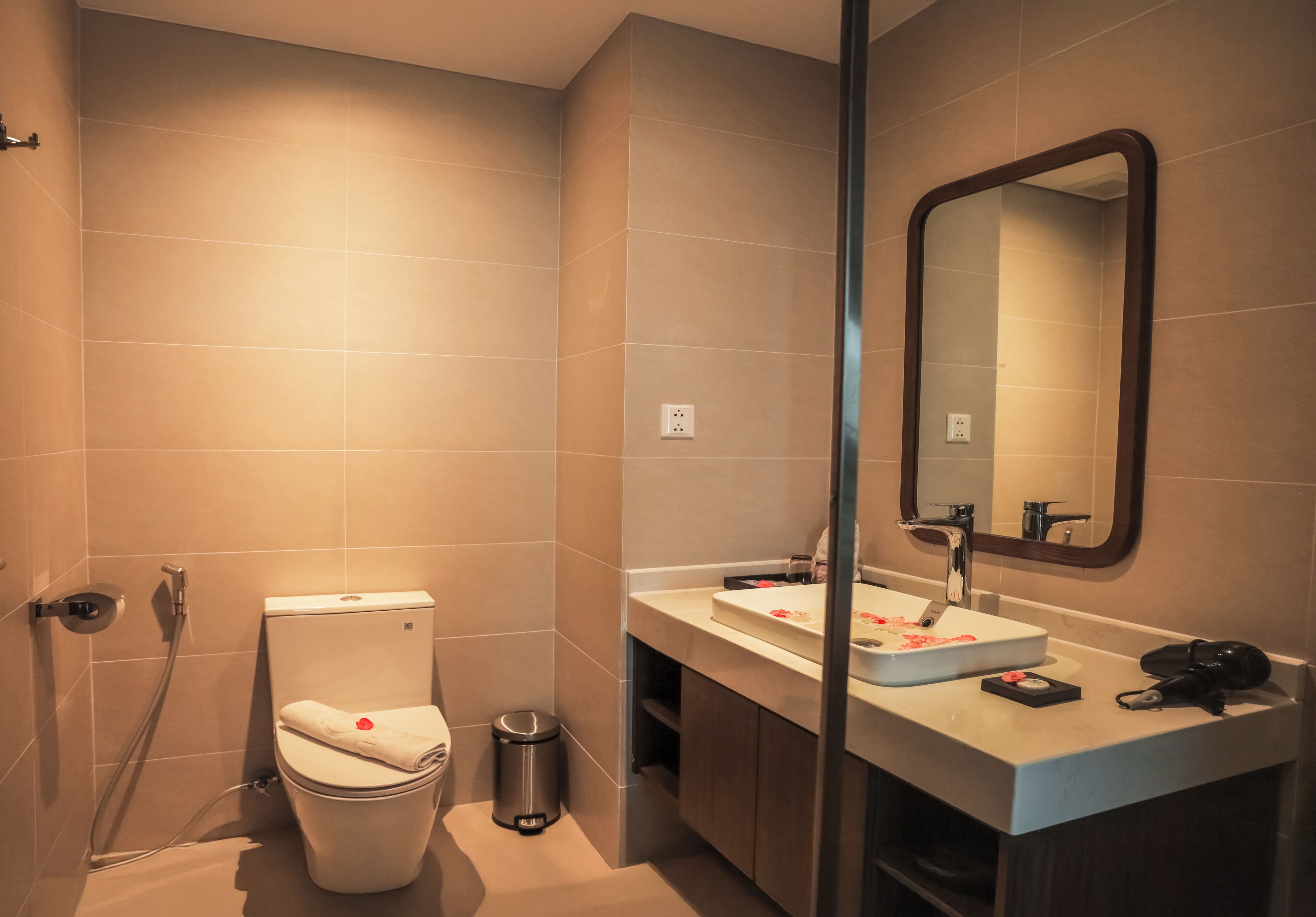 Een moderne badkamer met toilet, wastafel en spiegel.