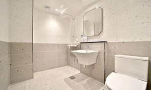 A modern bathroom with a shower, sink, and toilet.