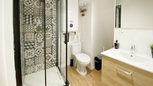 Un baño con ducha, inodoro y lavamanos.