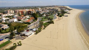 Eine Küstenregion mit Strandhäusern, einer Hauptstraße und einem Strand.