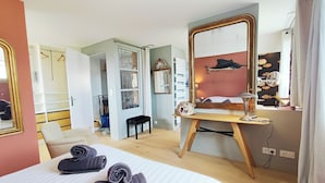 Een hotelkamer met een bed, een bureau, een spiegel en een kledingkast.