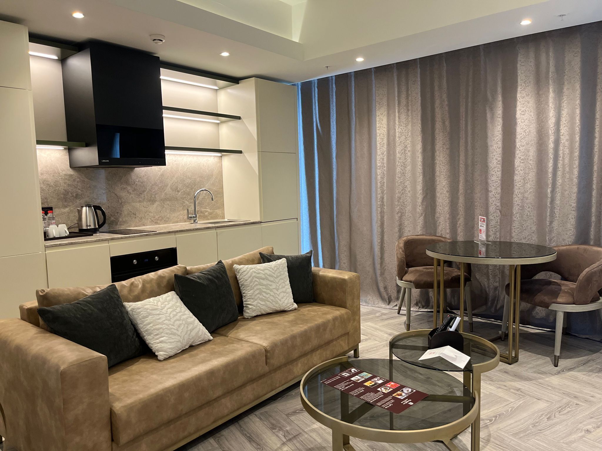 A modern living room with a sofa, coffee table, and dining area.