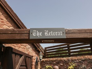A wooden pergola with a sign that reads "The Retreat." - The Retreat (Watchet)