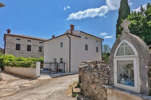 Un bâtiment en pierre de deux étages, doté d’une façade blanche et d’un petit clocher.