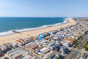 A coastal town with a beach, houses, and a road.