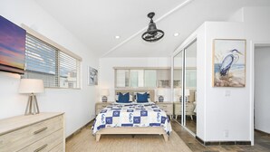 A bedroom with a bed, bedside tables, a ceiling fan, and a painting on the wall. - 4 Bedroom Home Steps from the Sand w/ Balcony&BBQ (Newport Beach)