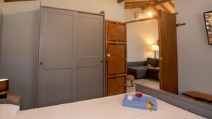 A bedroom with a bed, a wardrobe, a mirror, and a sofa in the background. - Sintra-Riviera by Interhome (Sintra)