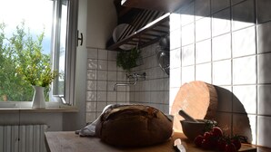 Eine Küche mit Brot, einem Schneidebrett und Tomaten auf der Arbeitsfläche.