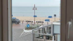 Une vue d’une plage avec un espace de stationnement et un bâtiment au premier plan.