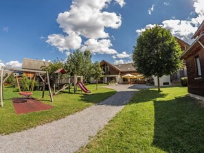Enjoy a family-friendly stay with a playground featuring a swing set and slide, surrounded by a beautifully manicured lawn and a convenient path to the lodge.
