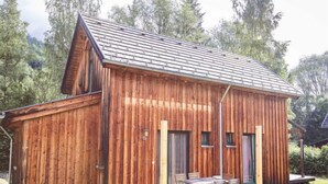 Eine Holzhütte mit einer Veranda und einem Tisch mit Stühlen.