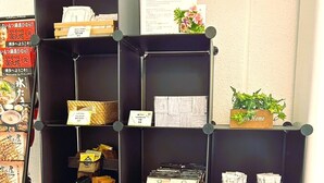 A black shelving unit with various items including baskets, boxes, and a sign. - Stay Airport (Fukuoka)