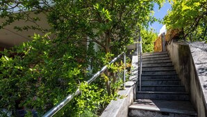 A concrete staircase with metal handrails, surrounded by lush green foliage. - Angelina by Interhome (Luino)