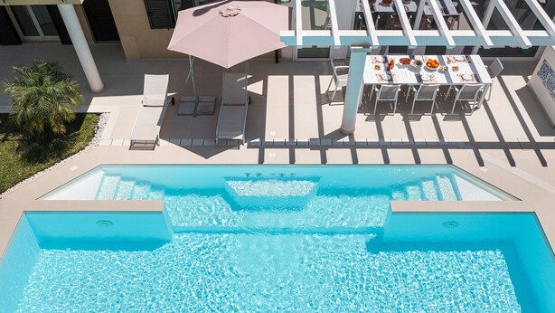A swimming pool with lounge chairs and a table with food and drinks. - Pool villa in Castelmola, Taormina, Sicily (Castelmola)