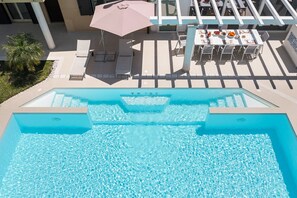 A swimming pool with lounge chairs and a table with food and drinks. - Private Pool villa in Castelmola, Taormina, Sicily (Castelmola)
