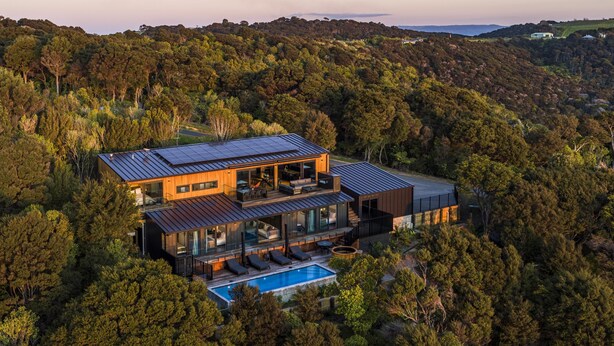 A modern two-story house with a large deck and a swimming pool, surrounded by dense forest. - Brand new luxury lodge in Onetangi, with pool, spa and sleeping 10 (Waiheke Island)