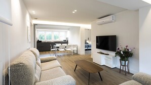 A modern living room with a sofa set, a coffee table, a TV, and a dining area with chairs and a table. - Villa Carmen by Basquelidays (Hondarribia)