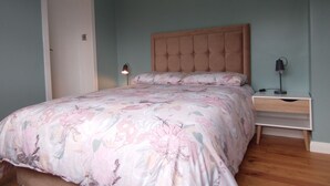 A bedroom with a bed, nightstands, and a door. - Lovely 3-bed House in Connemara, County Galway (Gowla)