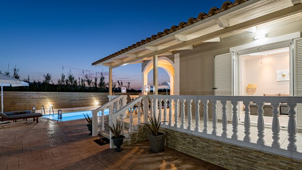 A pool area with a covered deck, potted plants, and a staircase leading to an upper level. - Blossom Villa (Zakynthos)
