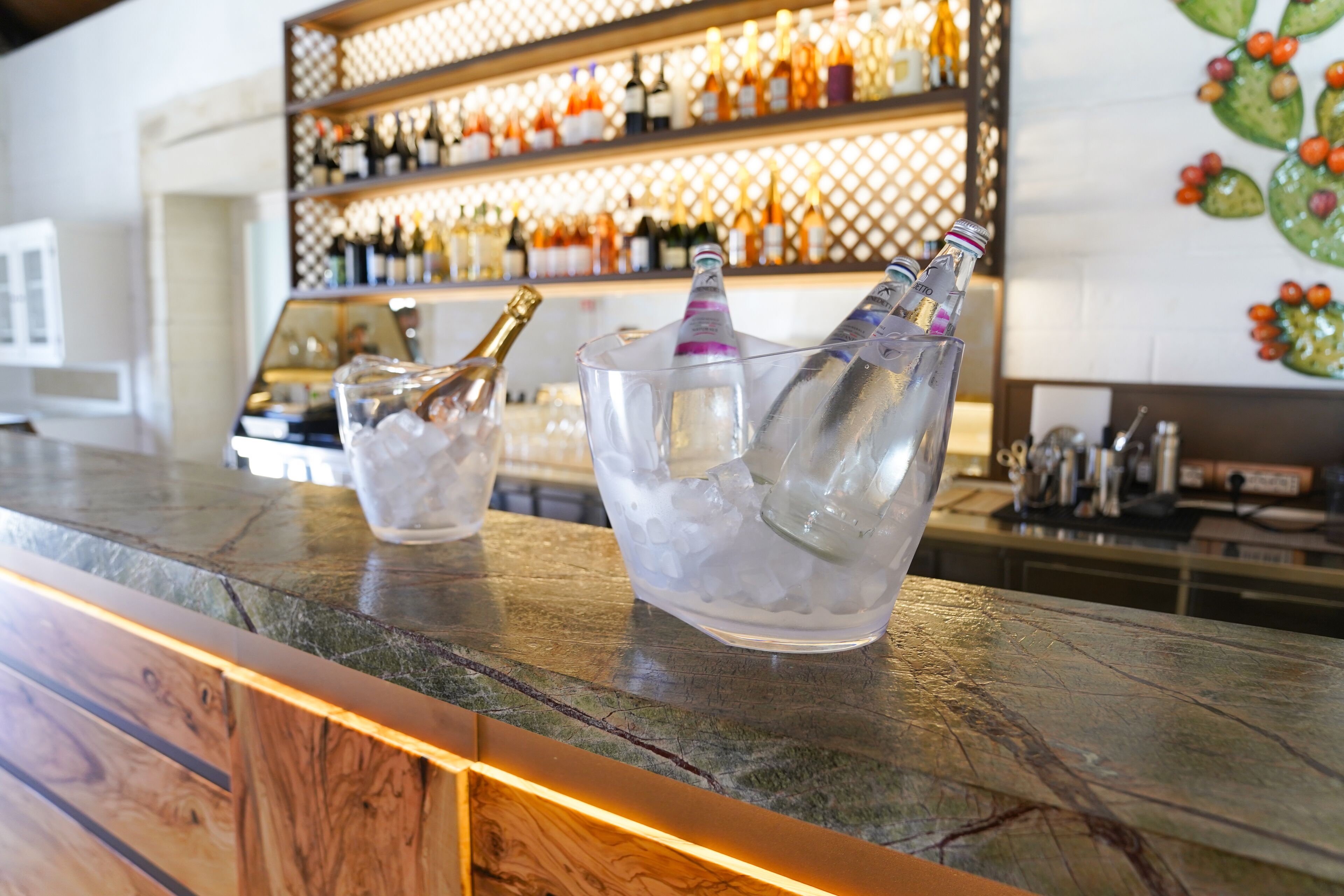 A bar area with ice-filled glasses and a wine bottle.