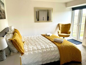 Une chambre d’hôtel avec un lit, une chaise, une armoire et une fenêtre.
