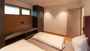 Ein modernes Schlafzimmer mit eingebauter Sitzbank, einem Kleiderschrank und einer Tür.