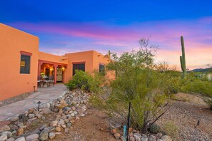 A building with a patio, a cactus, and a desert landscape.