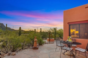 A patio with a table and chairs, surrounded by cacti and desert vegetation. - Cereus Vista- Outstanding Views (Tucson)