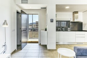 A modern kitchen with a stainless steel refrigerator, a built-in oven, and a window overlooking a cityscape. - Pet-Friendly 'Murtra Apartment' with Sea View, Shared Pool & Wi-Fi (Roses)