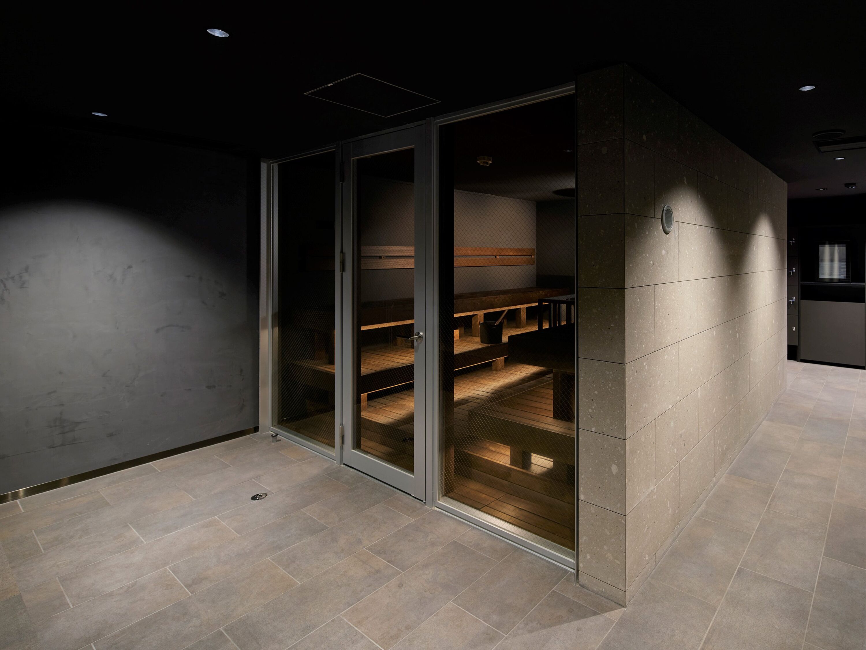 A modern room with a sliding glass door leading to a seating area with benches and a table.