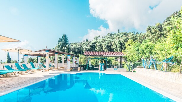 Una piscina amb gandules i un pavelló.