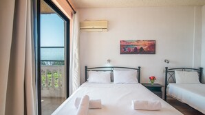 Habitació d'hotel amb un gran finestral, un quadre a la paret i dos llits amb tovalloles.