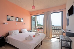 A hotel room with a bed, a desk, a chair, a balcony with a table, and a TV. - Andromaches sea view studio 2 with shared pool, balcony & Wi-Fi (Corfu)