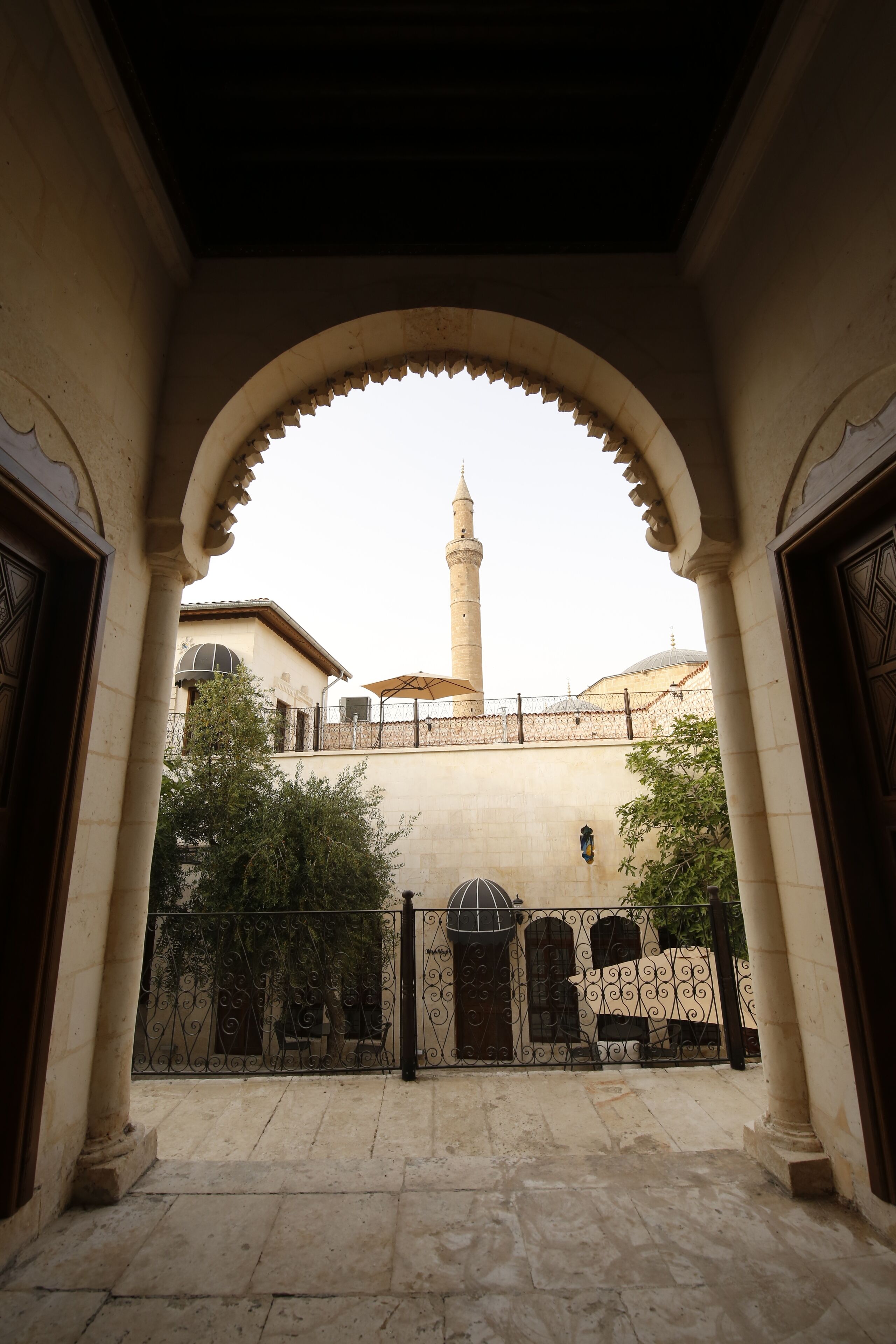 Una entrada arqueada que conduce a un patio con una mezquita al fondo.