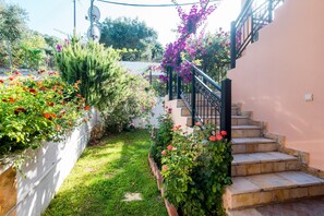Un jardin avec un escalier en pierre menant à un bâtiment.