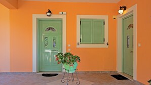 A hallway with two green doors, a potted plant, and a tiled floor. - 'Villa Pepy Apartment' with Sea View, Garden & Wi-Fi (Corfu)