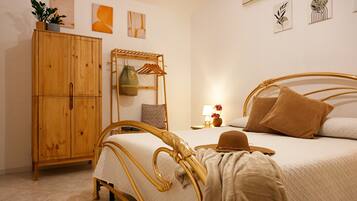 Una camera da letto con un'armadio in legno, un letto con testiera, un comodino con lampada e decorazioni alle pareti.