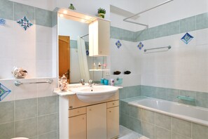 Banheira, secador de cabelo, toalhas de banho 