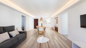 A modern living room with a sofa, dining table, and TV. - Holiday Apartment 'Albercutx Pollentia 3' Near the Beach with Private Terrace (Pollensa)