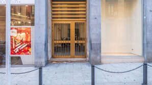 A building entrance with a metal gate, a chain barrier, and a large glass window on the right. - Apartment "Casa di Alice" with Sea View, Balcony and Wi-Fi (Siracusa)