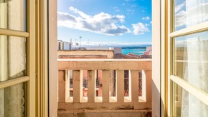 A balcony with a view of the sea and a building in the background. - Apartment "Casa di Alice" with Sea View, Balcony and Wi-Fi (Siracusa)