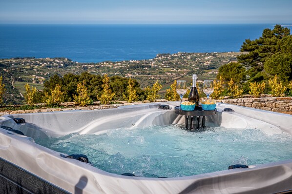 Un jacuzzi con vista al mar y una pared de piedra.