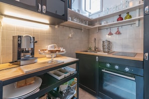 A modern kitchen with a coffee machine, a sink, and a stove.